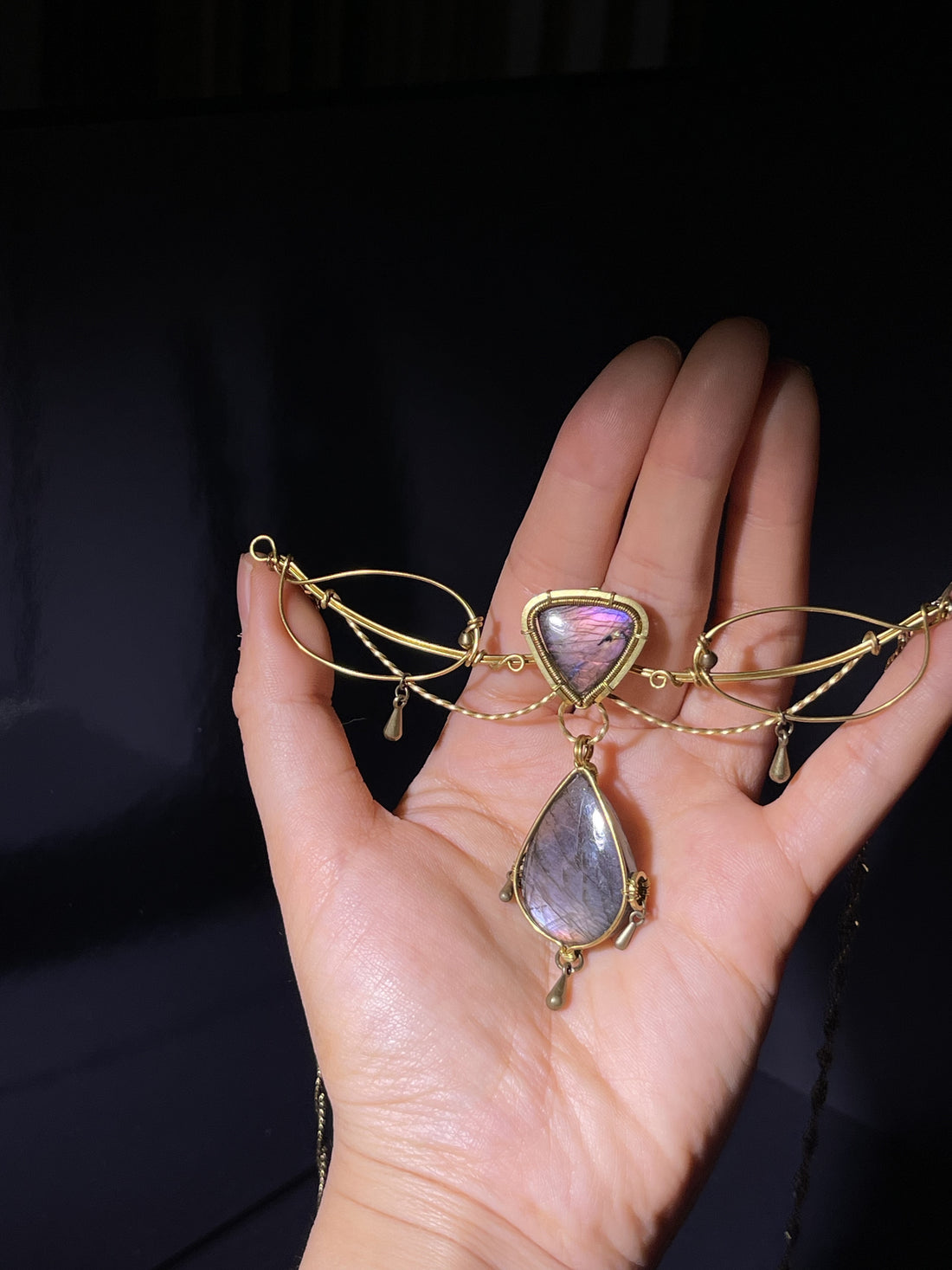 Handmade wire wrapped pendant with natural labradorite stone. Unique iridescent luster, vintage copper craft, delicate wearable ornament.